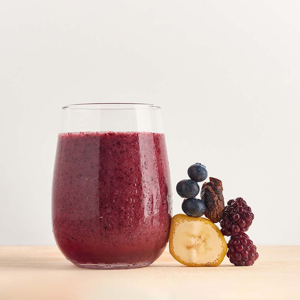 Healthy smoothie made with Detox ready-to-blend pack and ingredients on table