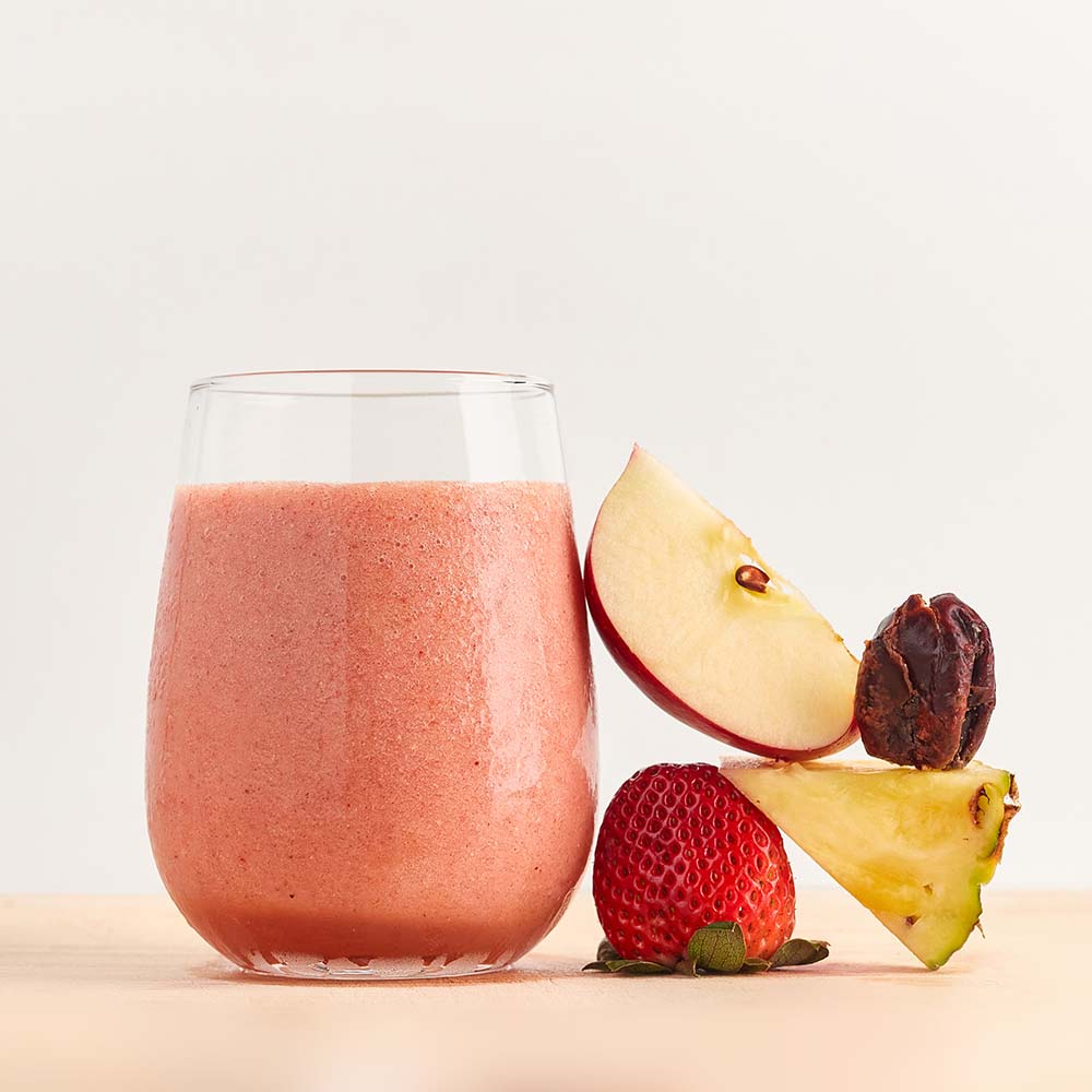 Healthy smoothie made with Energise ready-to-blend pack and ingredients on table