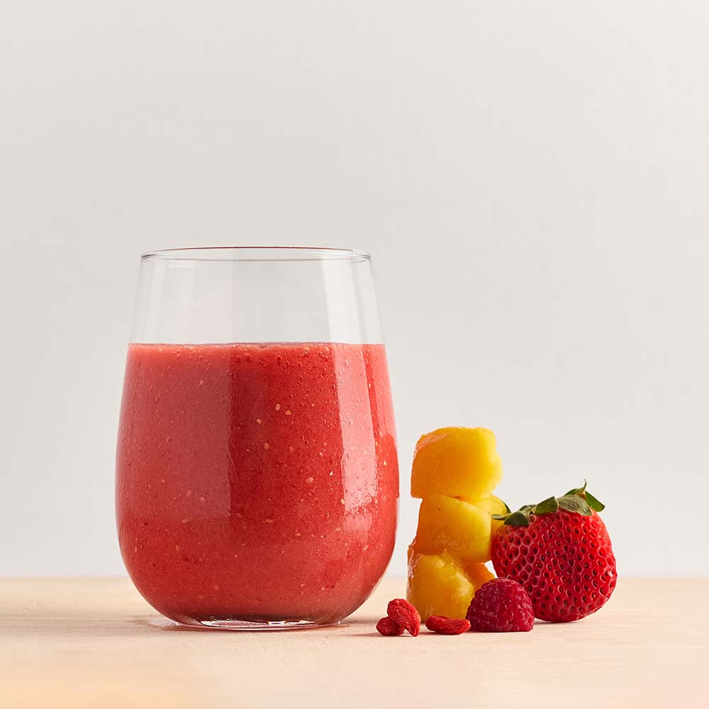 Healthy smoothie made with Vitality ready-to-blend pack and ingredients on table