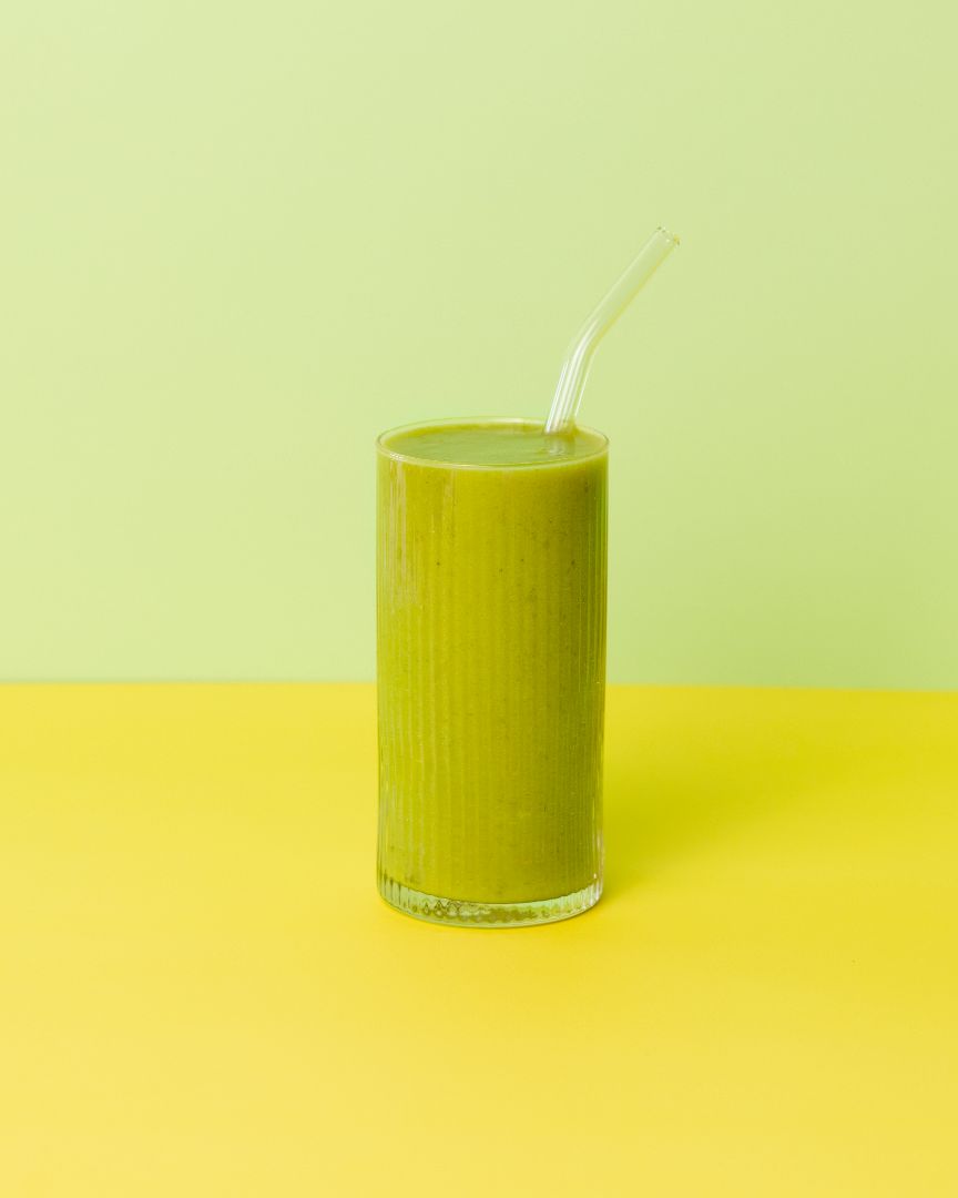 Healthy smoothie made with Booster ready-to-blend pack and ingredients on table